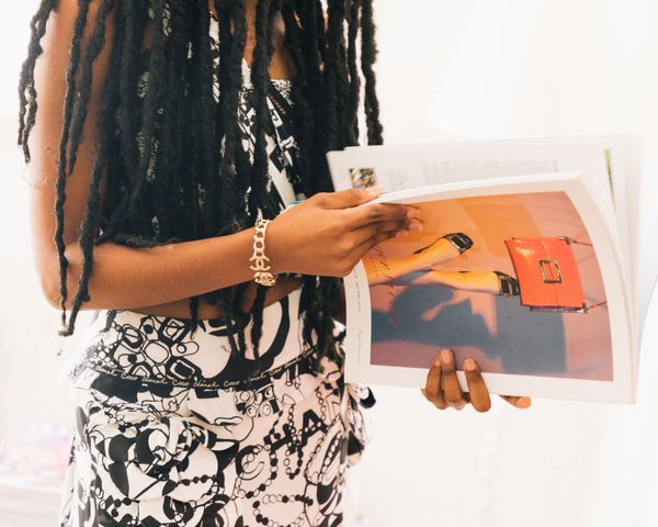 Destiny Joseph holding a magazine wearing a gold Chanel bracelet