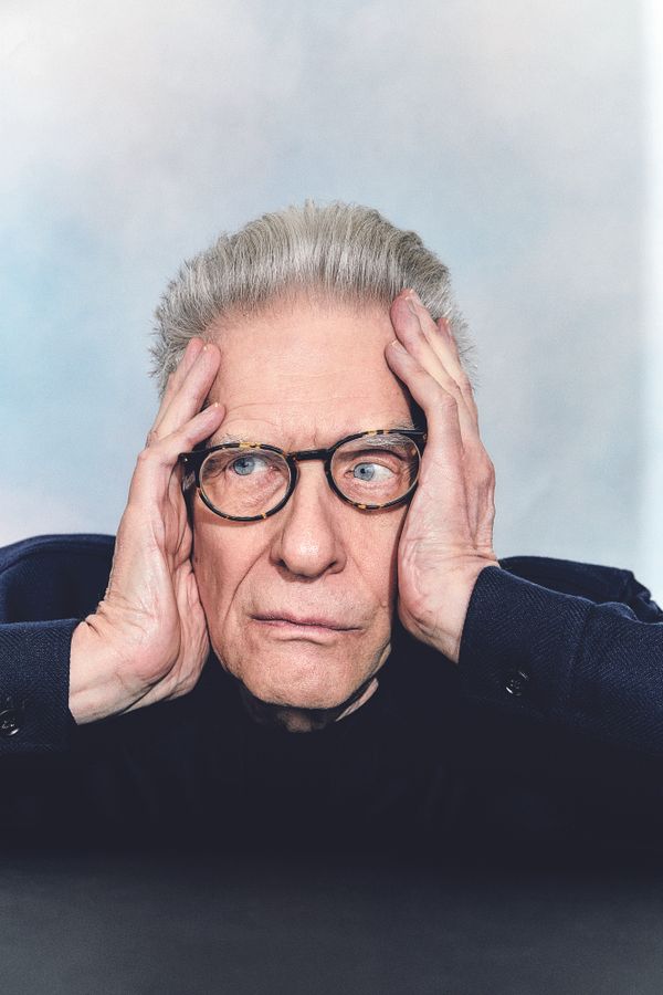 David Cronenberg posed with his hands on the sides of his face 