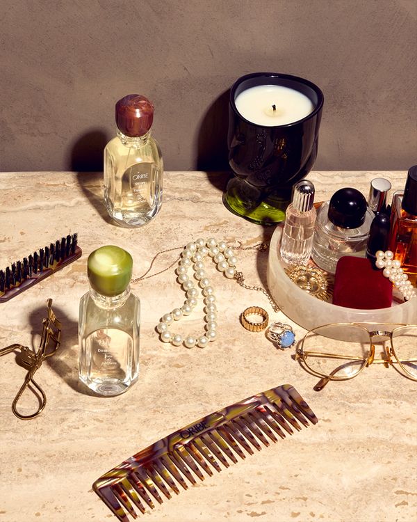 An assortment of Oribe products, jewelry and accessories organized on a countertop