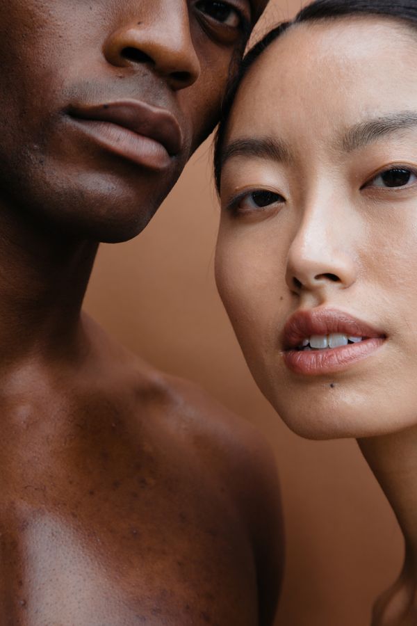 One female and one male model posed closely with faces touching
