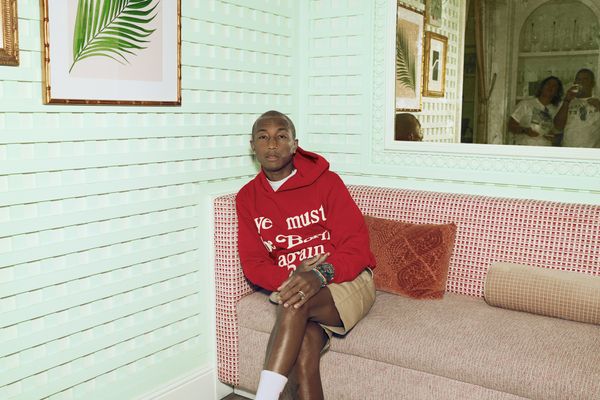 Pharrell Williams seated on a couch